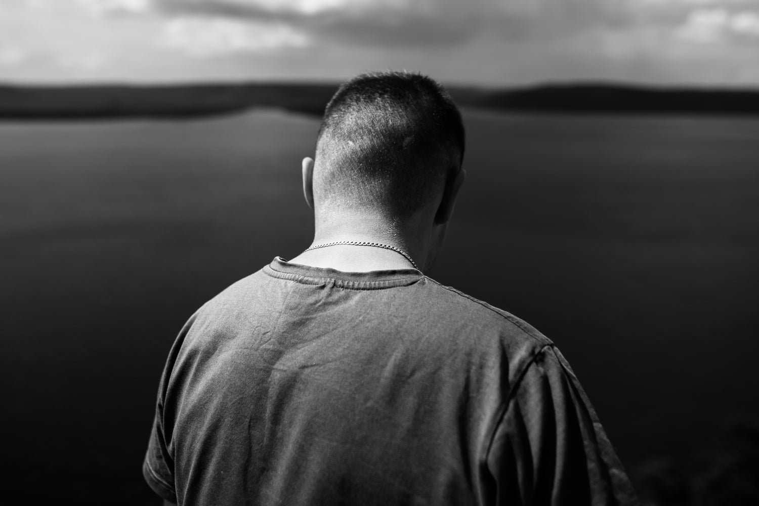 Traveler in purple shirt standing on top of rock mountain with amazing view on river